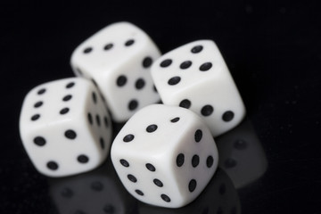Four white dices in a black background