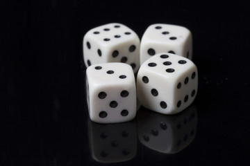 Four white dices in a black background