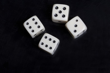 Four white dices in a black background
