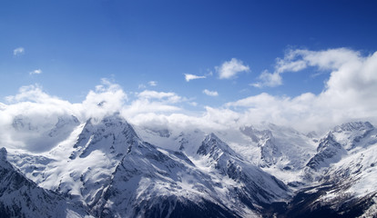 Panorama of snowy mountains in clouds