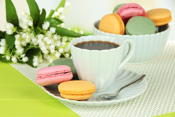 Coffee and macaroons on table on light background