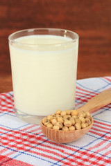Soy beans with glass of milk on table on wooden background