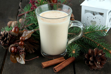 Cup of eggnog with fir branches and Christmas decorations