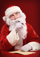 Portrait of Santa Claus looking at envelope in his hands
