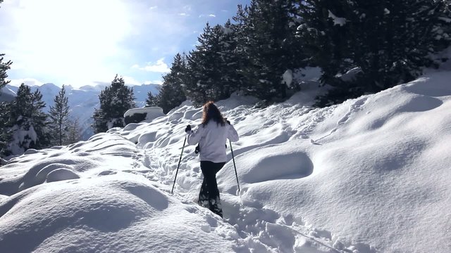 Ragazza che ciaspola in montagna
