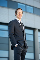 Smiling young businessman standing outdoors