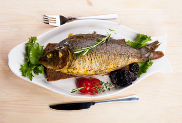 fried fish on a plate with vegetables