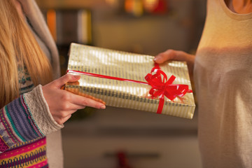 Closeup on two girlfriends exchanging christmas presents