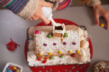 Obraz na płótnie Canvas Closeup on teenage girl decorating christmas cookie house