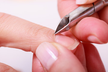 Beautician trimming cuticles female client. Manicure salon