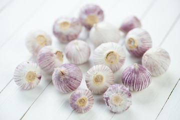 Bulbs of chinese solo garlic, white wooden background