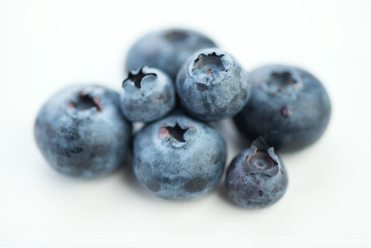 Macro shot of ripe blueberries, white wooden background
