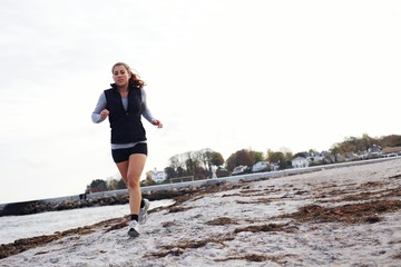 Young woman jogging along beach
