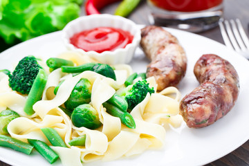 Fettuccine with vegetables and fried sausages