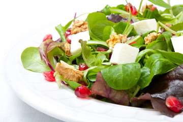 Mix salad with pomegranate, cheese and nuts
