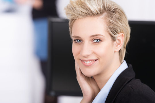 lächelnde blonde geschäftsfrau am arbeitsplatz