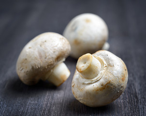 Fresh champignons on black wooden board