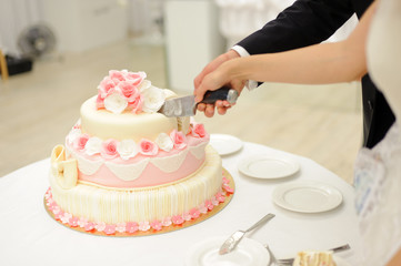 bride and groom cutting elegant cake with roses