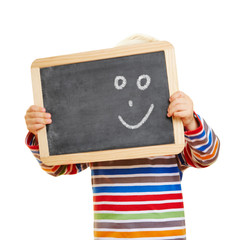 Kind hält Tafel mit Smiley vor Gesicht