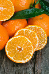 Tangerines with leaves on wooden table