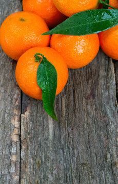 Tangerines with leaves on wooden table