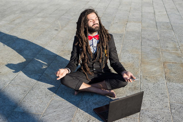 Stylish elegant dreadlocks businessman using notebook