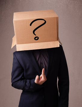 Young man gesturing with a cardboard box on his head with questi