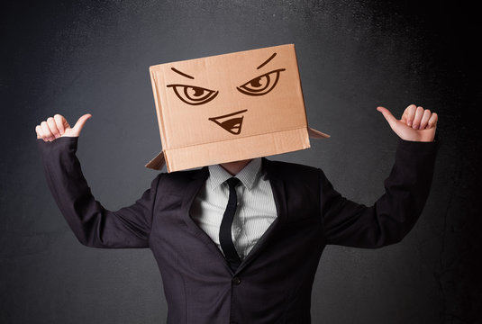 Businessman gesturing with a cardboard box on his head with evil