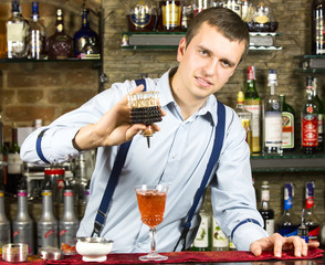 young man working as a bartender in a nightclub bar