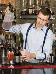 young man working as a bartender in a nightclub bar