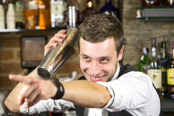 young man working as a bartender in a nightclub bar