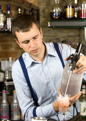 young man working as a bartender in a nightclub bar
