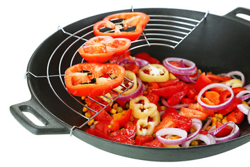 Vegetables in wok isolated on white