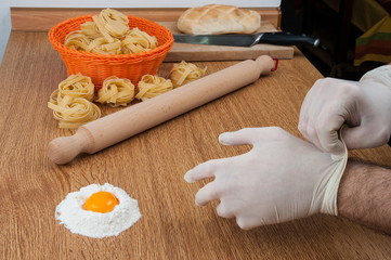Obraz na płótnie Canvas Guanti igienici in cucina per impastare farina e uova