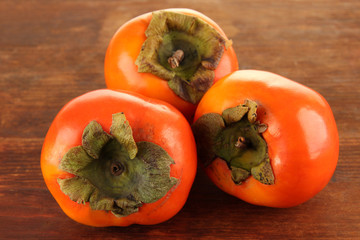 Ripe persimmons on wooden background