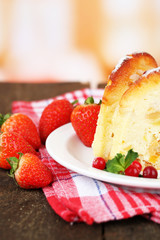 Slice of tasty homemade cake with berries, on wooden table