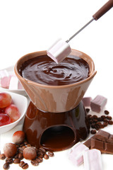 Chocolate fondue with marshmallow candies and fruits, isolated