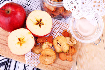 Obraz na płótnie Canvas Dried apples in glass jar, on color wooden background