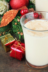 Cup of eggnog with fir branches and Christmas decorations close