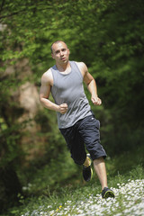 Young man running in the woods