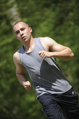 Fototapeta premium Young man running in the woods