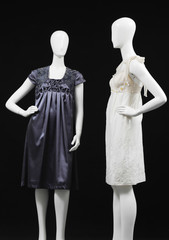 Two mannequin gray and white sundress on black background