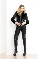 Fototapeta premium standing woman wearing fashionable black clothes and boots