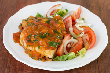chicken with sauce and salad on plate