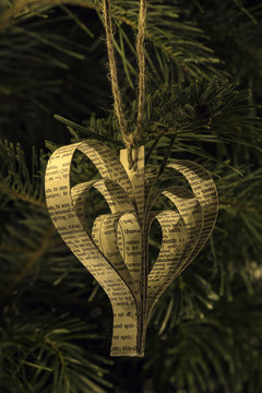 Hand made paper heart shape christmas toy on the tree