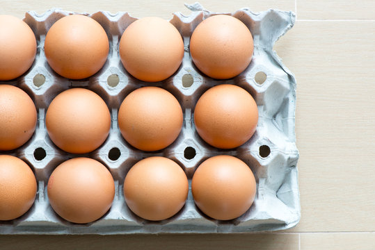 Eggs on the tray with light wooden background