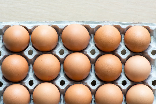 Eggs on the tray with light wooden background