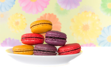 Plate of sweet colorful macaron on table