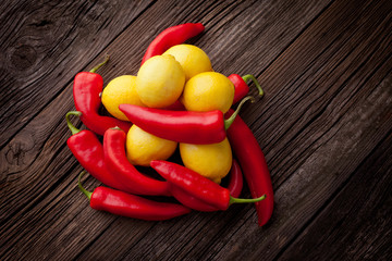 Fresh red chilli and lemons on a wooden table