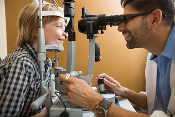 Optometrist Examining Boy's Eyes With Slit Lamp
